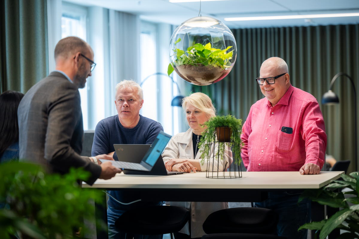 Fyra personer som arbetar vid ett ståbord